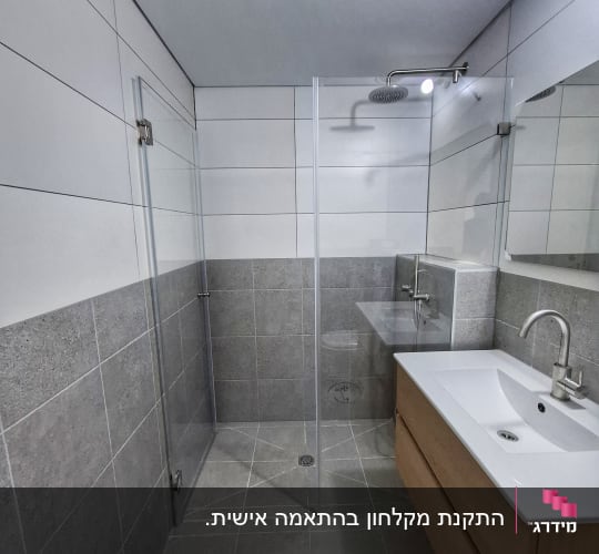 מקלחת עם דלת זכוכית וראש מקלחת עגול